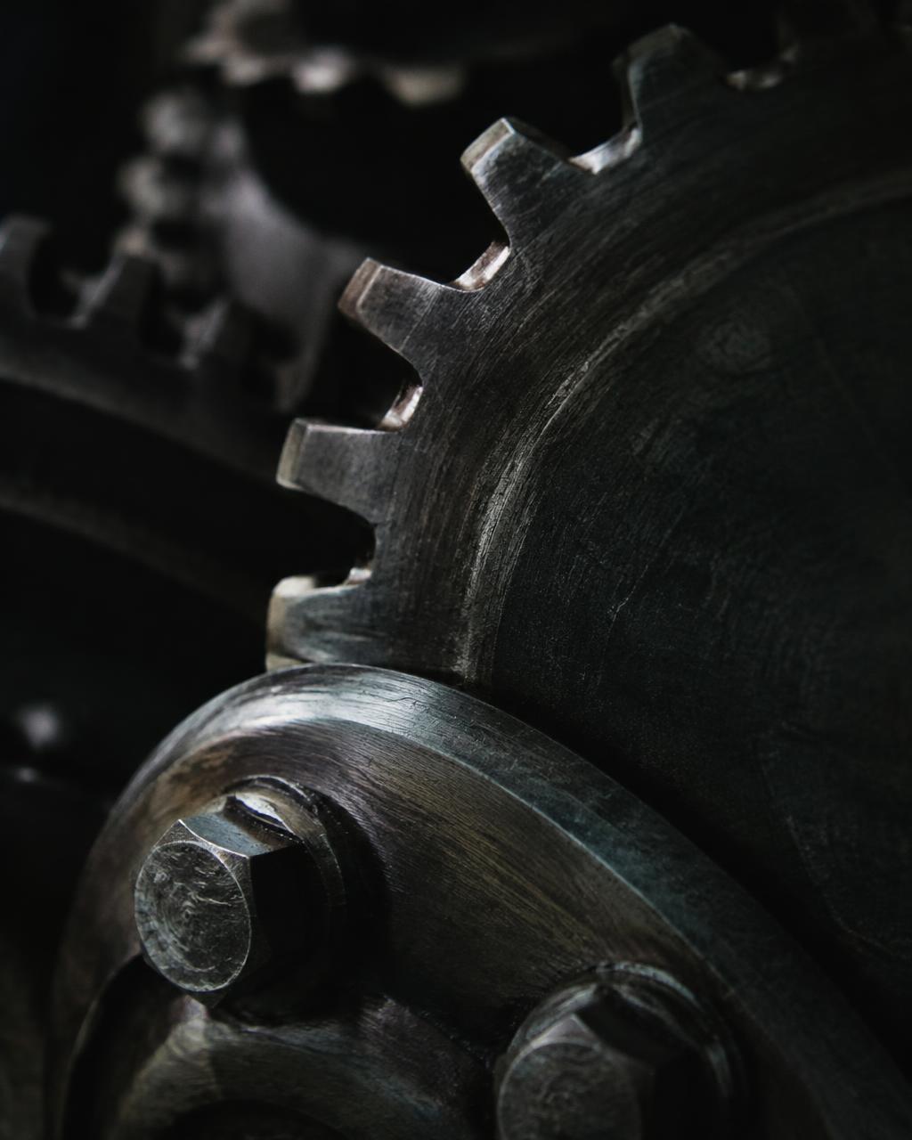 Close-up of worn steel gear teeth and bolts